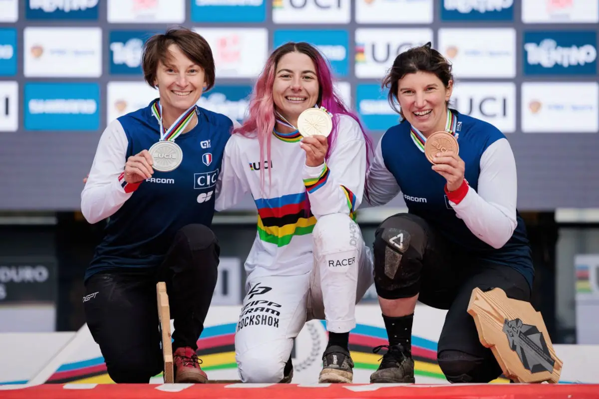 Isabeau COURDURIER championne du monde de vtt enduro edr sur le podium avec son maillot et sa médaille d'or et avec Mélanie PUGIN medaille d'argent et Morgane CHARRE medaille de bronze